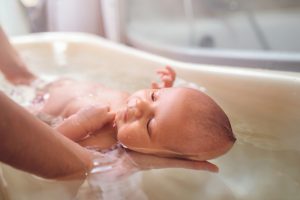 Manos bañando a un recién nacido