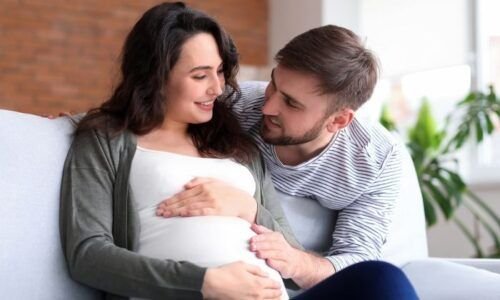 Pareja con las manos sobre la bariga de la mujer embarazada