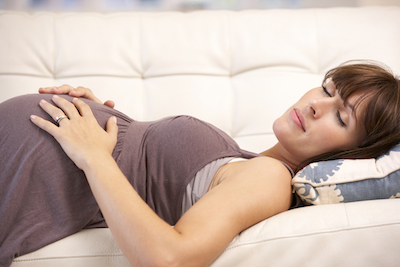 Mujer embarazada en el sofá relajadamente