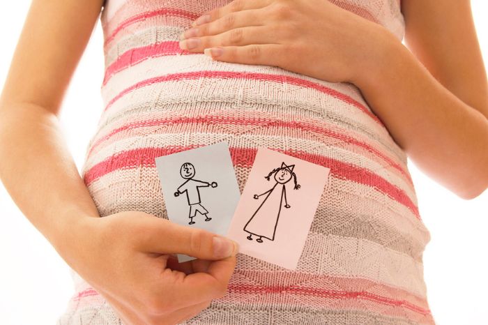 Mujer embarazada con dos dibujos de niño y niña